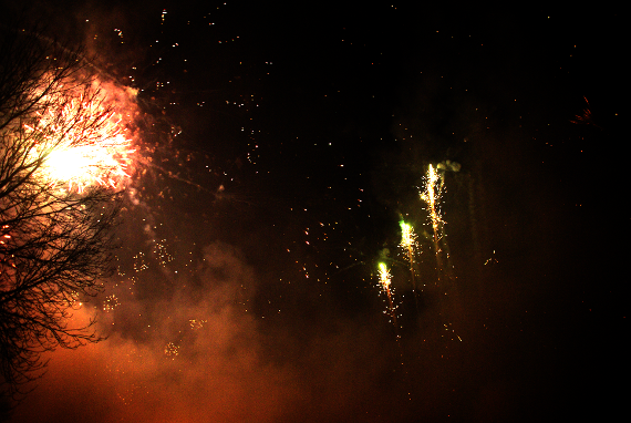 Das Bild zeigt eine nächtliche Aufnahme von mehreren explodierenden Silvesterraken